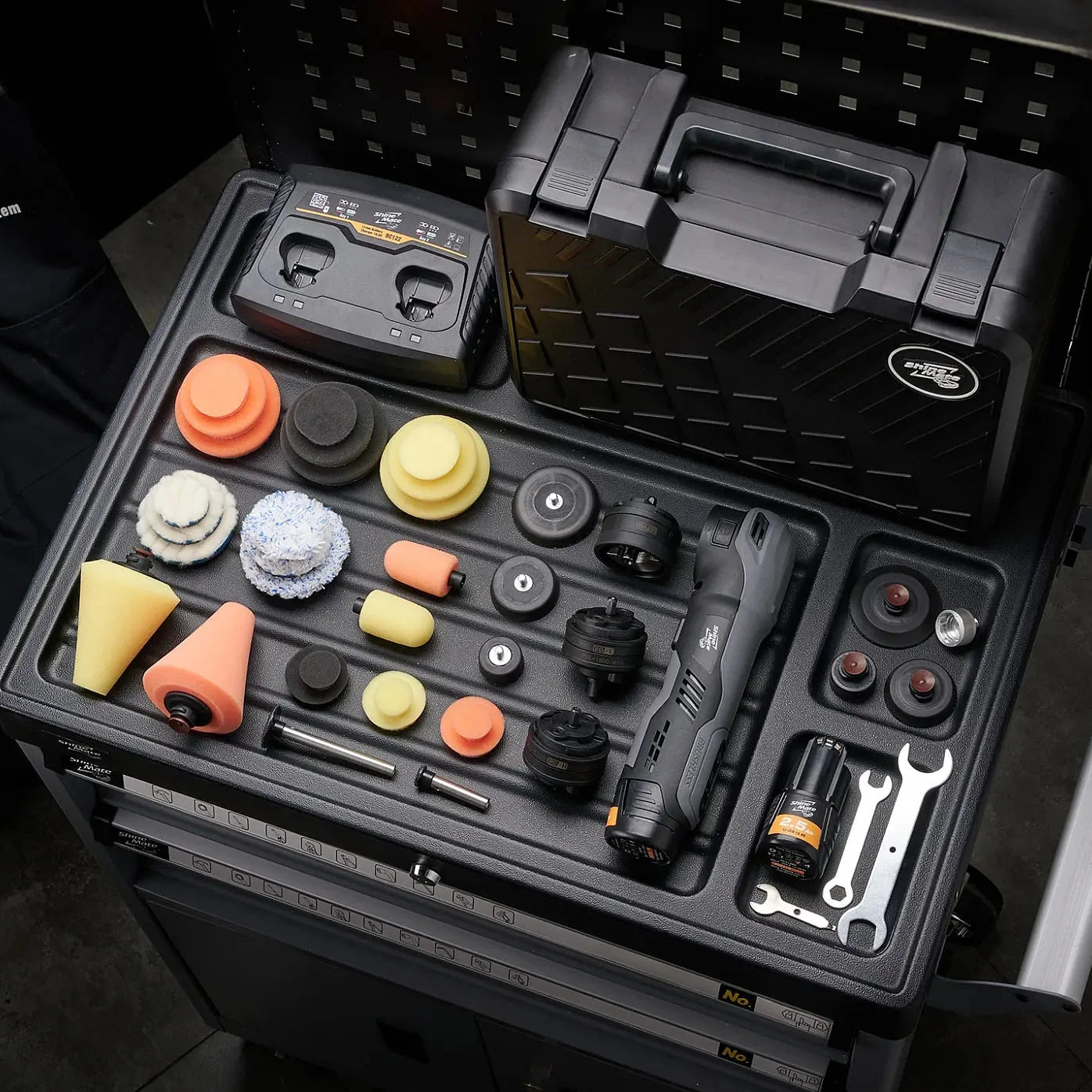 Black tool case with various tools and attachments on a dark background