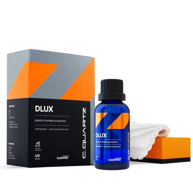 A product image featuring CarPro CQuartz DLUX, which includes a blue bottle with a black cap, an orange and black box, and a white cloth. The product is marketed as a plastic and rubber protection solution.