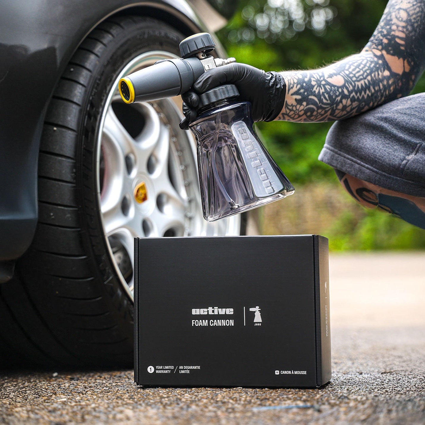 Person using the Active™ Premium Foam Cannon to a car tire with 'active' foam cannon packaging.