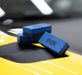 Blue Gyeon applicator block on a yellow car surface