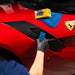 Person applying Gyeon PPF Ceramic Coating to a red car with a Ferrari logo.