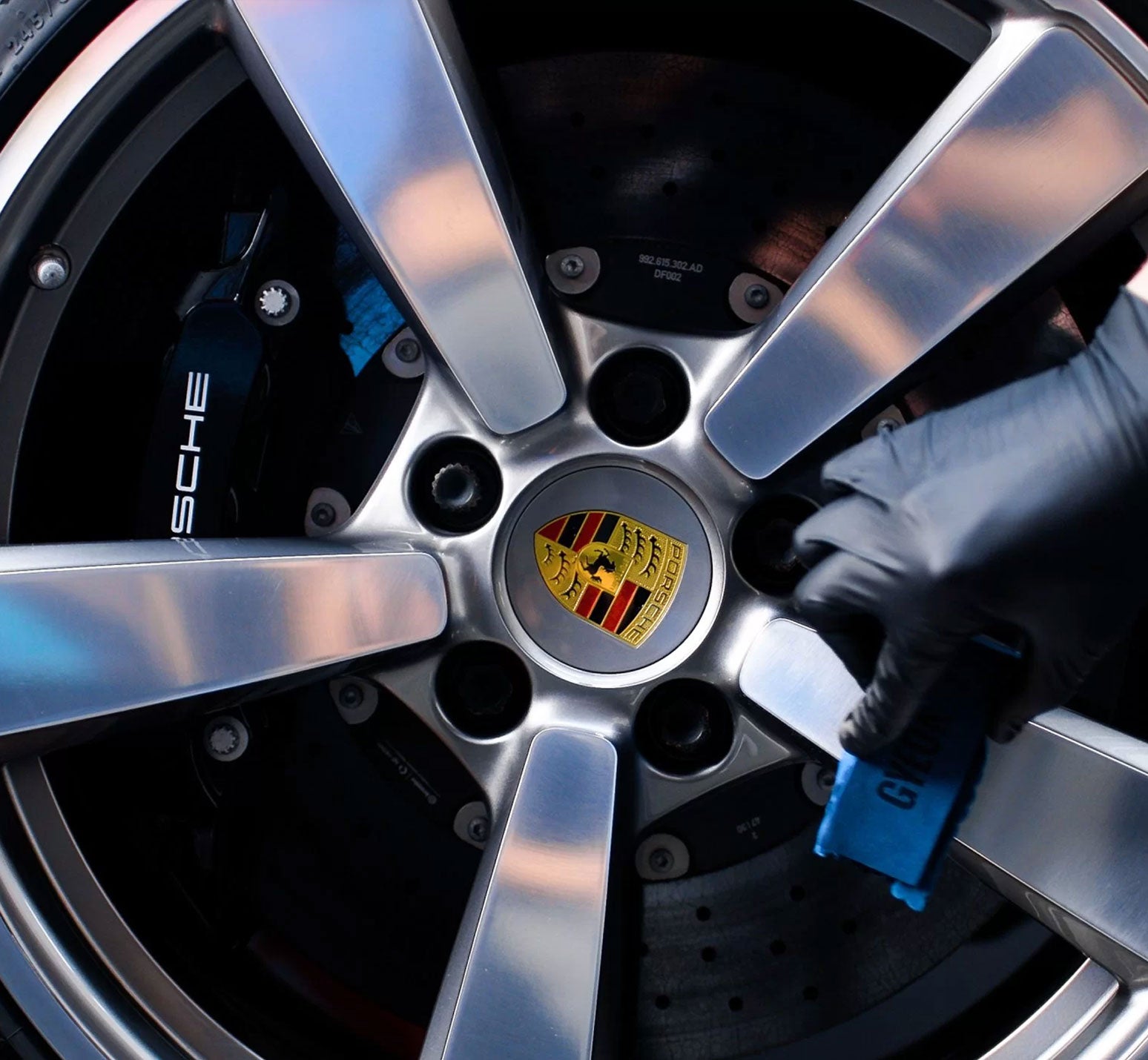 Close-up of a Porsche car wheel with the brand logo.