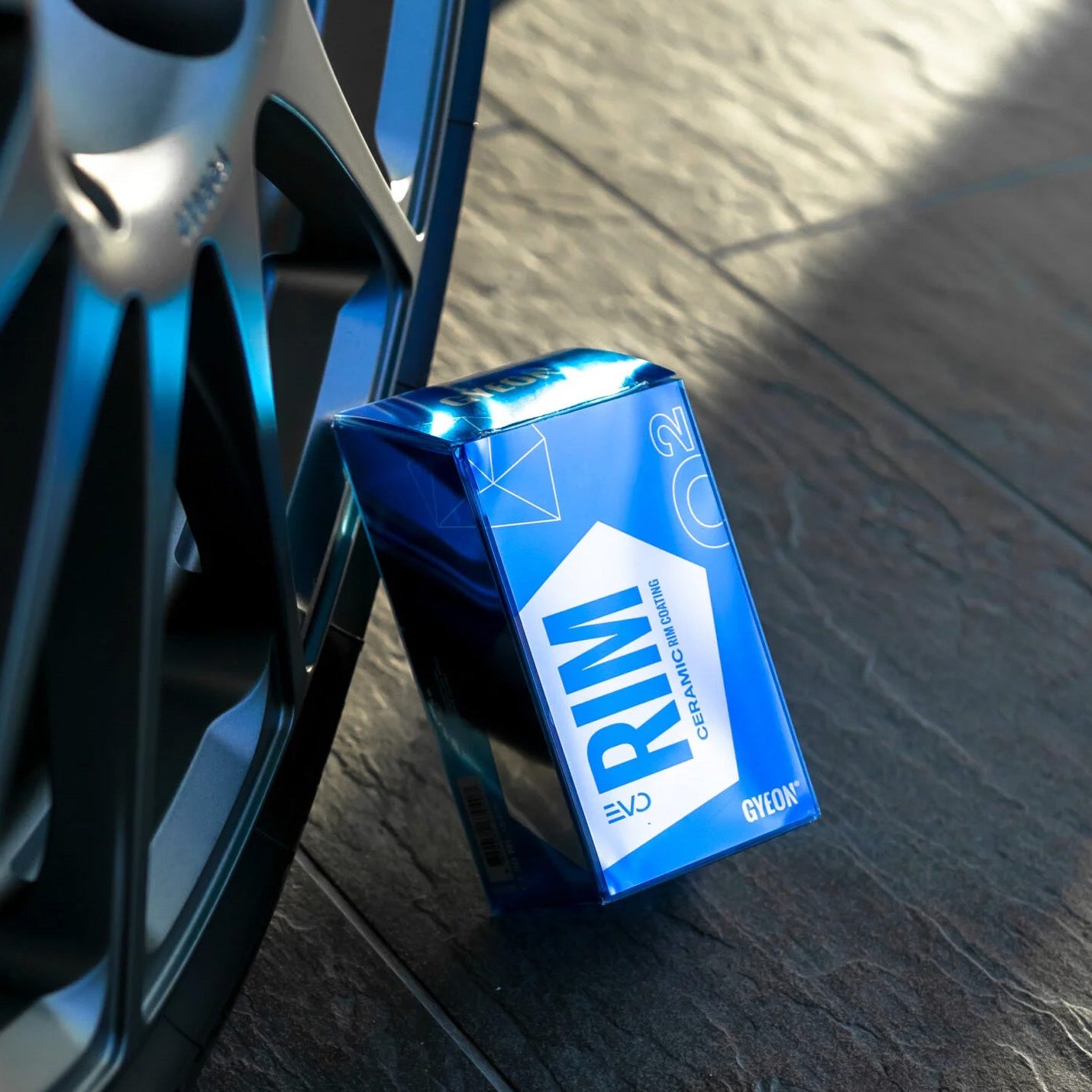 Box of Rim ceramic cleaner next to a car wheel on a wooden floor