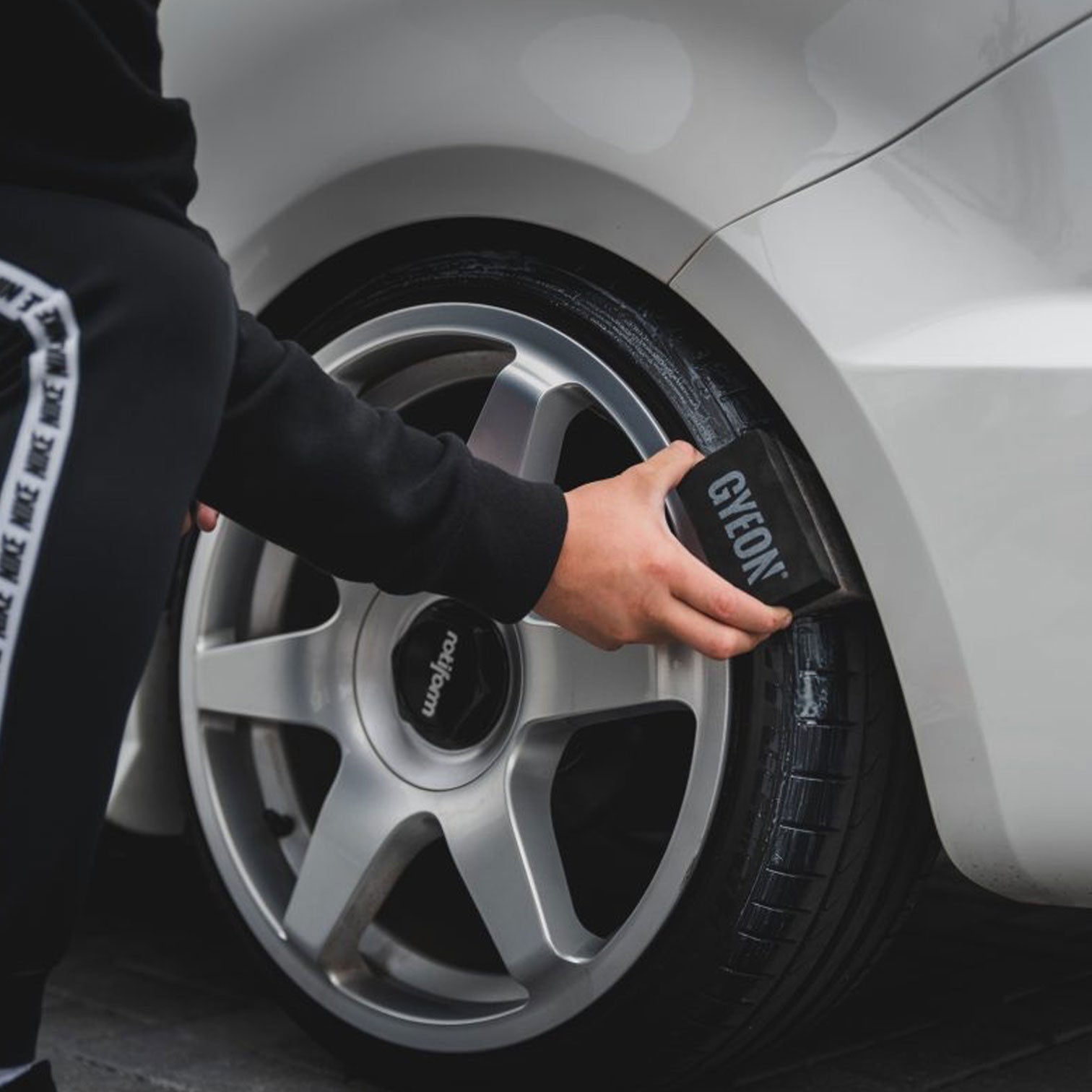 Person using a Gyeon Tire Dressing Applicator on a car tire