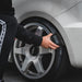 Person using a Gyeon Tire Dressing Applicator on a car tire