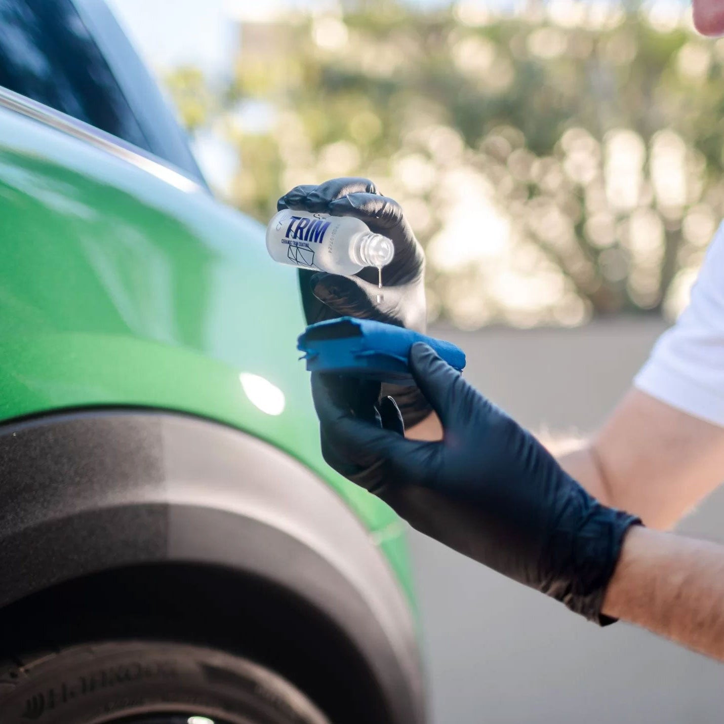Person applying Gyeon Trim coating to with a cloth outdoors