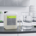 Koch-Chemie PreFoam Efficient alkaline pre-wash cleaner in a large container with measuring cylinders on a workbench.