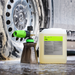 Koch-Chemie PreFoam Efficient alkaline pre-wash cleaner bottle and foam cannon used on a dirty car wheel.