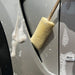 Sponge Guru Oval Wheel Brush on a car door with visible soap suds