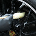 Person cleaning a Sponge Guru Oval Wheel Brush